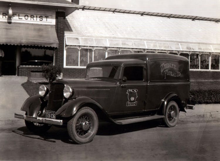 An early delivery vehicle, emblazoned with the Zeidler name, parks outside our storefront